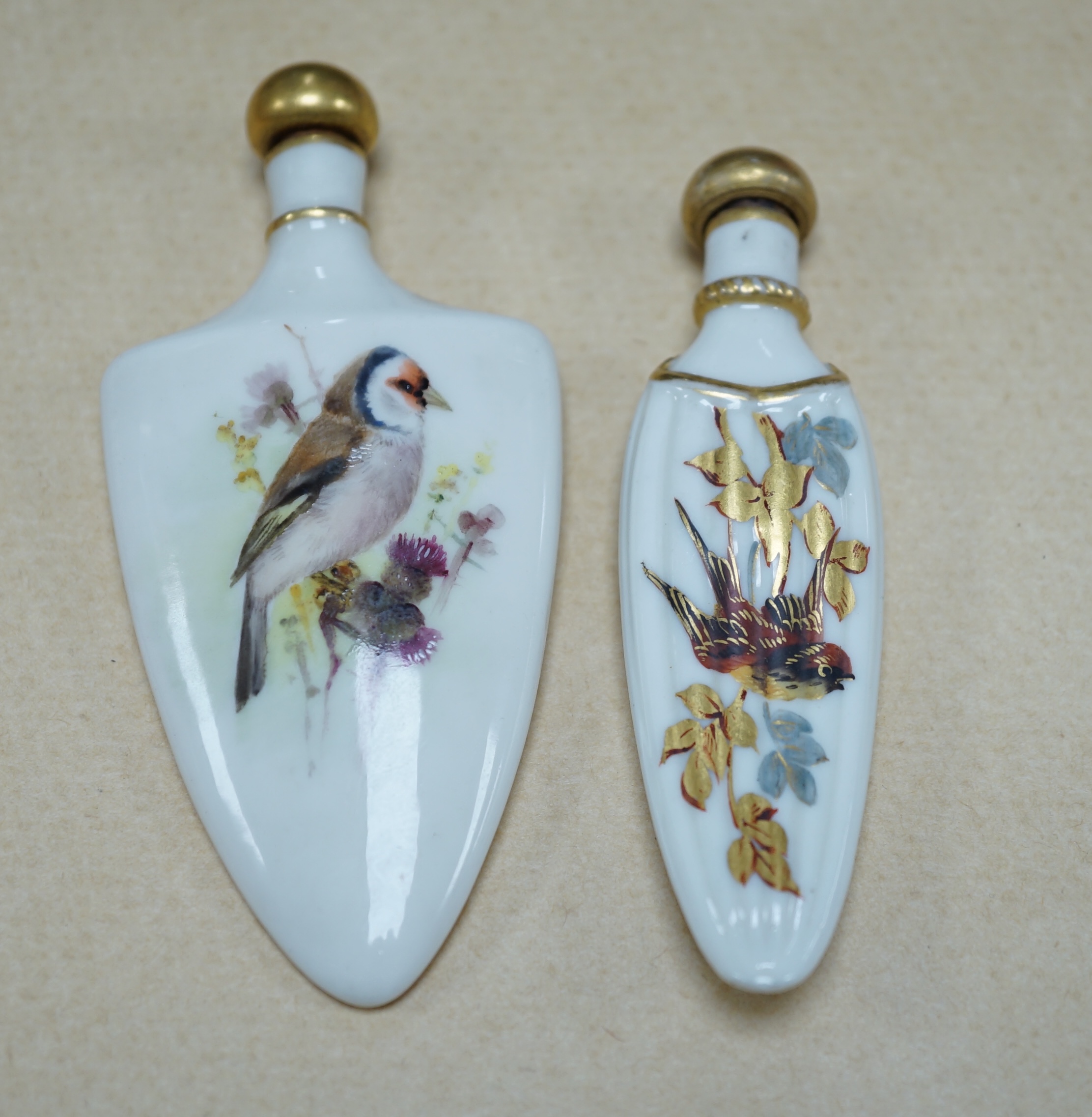 An unusual Royal Worcester bird painted scent flask and another similar flask, longest 10cm. Condition - cork to one stopper broken, unsigned